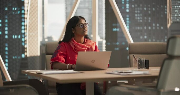 Empowering Portrait of an Indian Businesswoman Working on Laptop Computer in a Fintech Startup Company. Financial Analyst Conducts Research in Emerging South Asian Stock Market