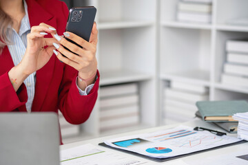 Consultant, Asian businesswoman working on the phone who discussion financial work and marketing business plan to increase company profits, ready to use computer and marketing planning documents.