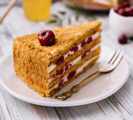 Homemade honey cake with cherry on plate