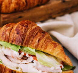 croissant sandwich with ham, tomato and lettuce
