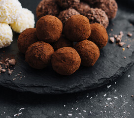 three types of chocolate balls on stone board