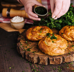 woman sprinkles dill fresh on twisted bun