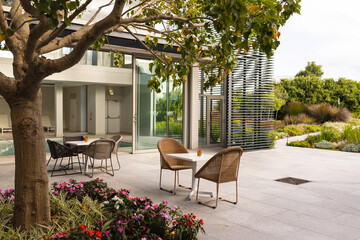 Empty chairs around table at patio outside modern hotel