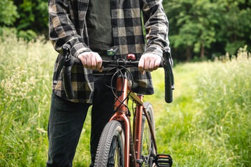 A man riding with a bike on a summer forest road.