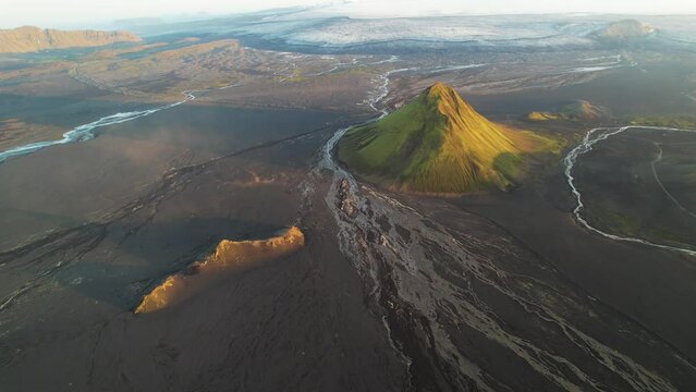 Aerial view of Maelifell mountain at sunset, a tall volcano that stands out in a desert of black sands, Iceland.