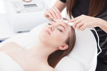 Fototapeta na wymiar Patient of a beauty salon during facial treatments.