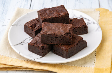 Brownies on a plate over white wooden table