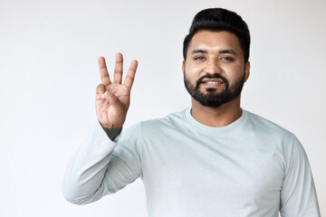 Naklejka premium Confident Happy Smiling South Asian Man Pointing Up three fingers, number 3 Gesture for Success, Goal, Direction concept on Isolated Background