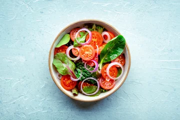 Dekokissen Salad with tomato, fresh leaves, and onions, overhead flat lay shot. Healthy diet, simple vegan recipe © laplateresca