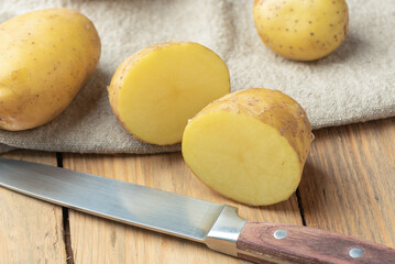 Close-up of a kitchen knife and a cut potato tuber.