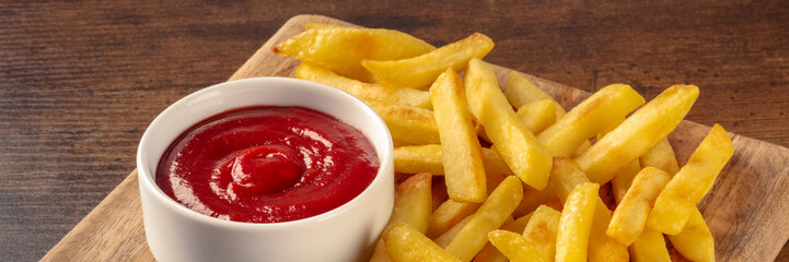 French fries, potato snack with ketchup, fast food on a wooden table, a panorama for a menu
