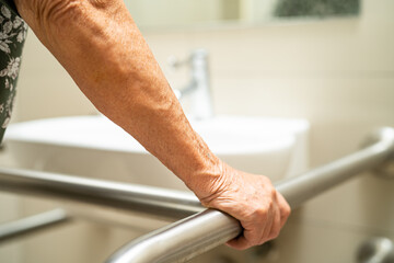 Asian elderly woman patient use toilet bathroom handle security in nursing hospital, healthy strong medical concept.