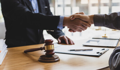 Businessman shaking hands to seal a deal with his partner lawyers or attorneys discussing a...