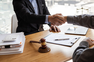 Businessman shaking hands to seal a deal with his partner lawyers or attorneys discussing a contract agreement.