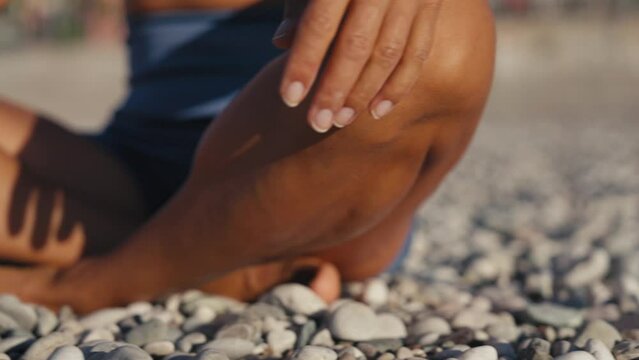 Woman with short hair sitting in lotus position doing yoga exercise meditating on beautiful beach . Girl on holidays sitting on seaside on cloudy day. High quality 4k footage