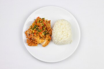 nasi ayam geprek or Spicy Geprek chicken rice culinary served on a round white plate. Most favourite dish in Indonesia.
