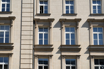 Facade of old tenement houses in Poland. Historical old town residential architecture. Building windows.