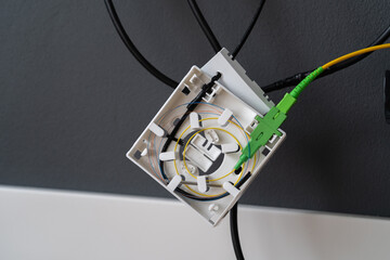 Installation of fiber optic cable in a box on the wall at home. High speed internet connection, new network equipment for a house.