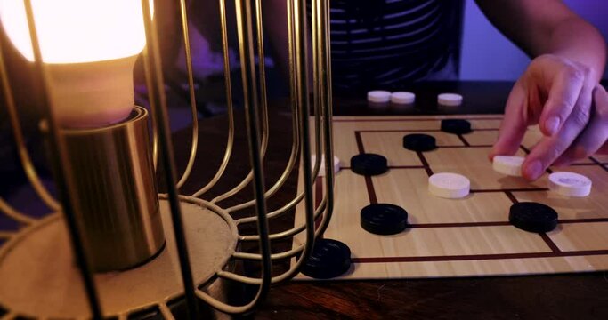 Two People Playing Mills Board Game aka Nine Men's Morris