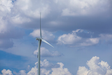 Fototapeta na wymiar Wind turbine on the brown grass over mountain the blue