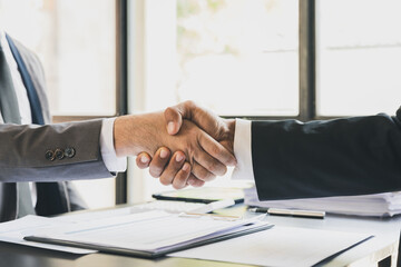 Two confident business man shaking hands during a meeting in the office, success, dealing, greeting. Two colleagues handshaking after meeting. Successful businessmen handshaking after deal.