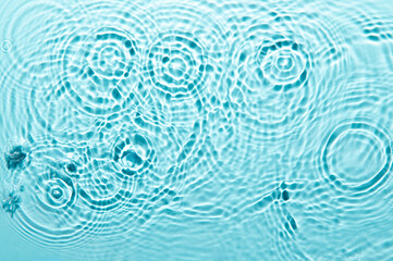 Fototapeta na wymiar Defocus blurred blue color water ripple surface clear calm texture background with splashing bubbles water drop. Abstract and nature concept. Shiny water wave sunlight reflection shining copy space.