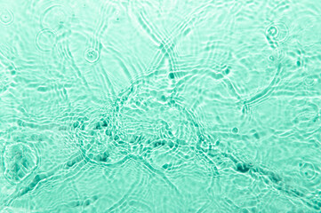 Defocus blurred blue color water ripple surface clear calm texture background with splashing bubbles water drop. Abstract and nature concept. Shiny water wave sunlight reflection shining copy space.