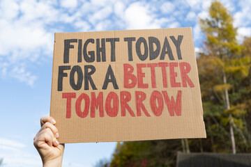 Woman holding placard sign with text Fight Today For a Better Tomorrow. Female protestor with...