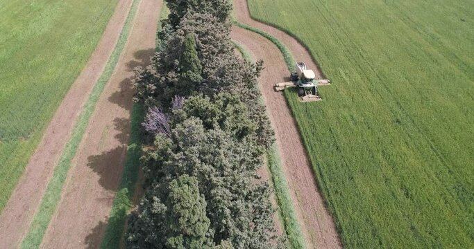 Aerial view of a agricultural machinery at action in a wheat field, Kibbutz Saar, Israel.