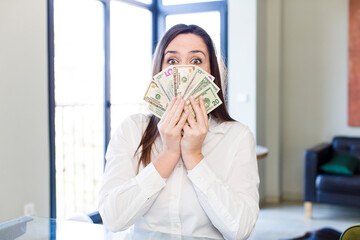 young adult pretty woman with dollar banknotes at home