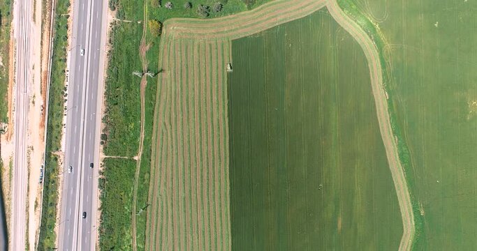 Aerial view of a agricultural machinery at action in a wheat field, Kibbutz Saar, Israel.