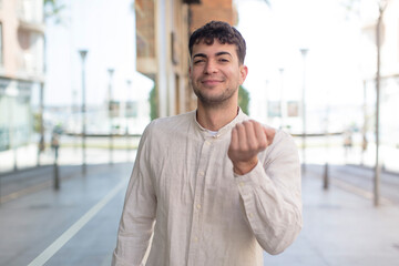 young handsome man feeling happy, successful and confident, facing a challenge and saying bring it on! or welcoming you