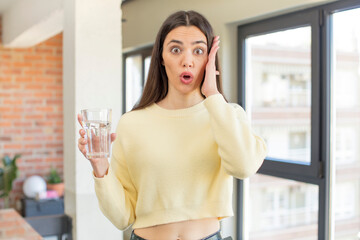 pretty young model feeling extremely shocked and surprised. water glass concept