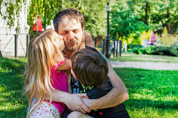 Fototapeta na wymiar happy dad hugs children girl and boy in nature. Family holiday