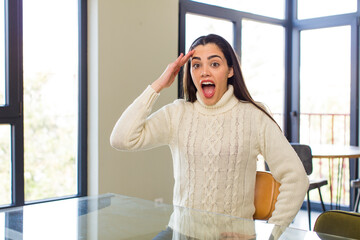 pretty caucasian woman looking happy, astonished and surprised, smiling and realizing amazing and incredible good news