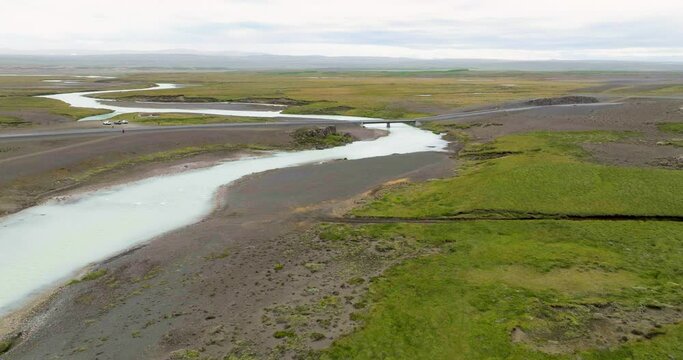 Aerial view of Kjolur road with bridge over river Sanda and tourists exploring in the desolate highlands of Iceland.