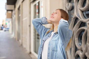 pretty young woman smiling and feeling relaxed, satisfied and carefree, laughing positively and chilling