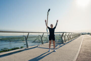 Fitness young sportswoman girl in the morning doing warm-up exercises before training on the street in the city on the bridge Sport health