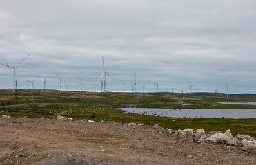View of a wind farm with turbines for generating electricity in the mountain tundra. Northern Wind power plant on the Kola Peninsula