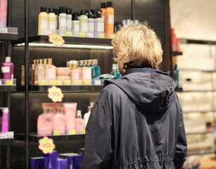 buying make up at cosmetics section in store. choosing cosmetics, perfumes, creams and shampoos, Using tester.