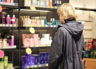 buying make up at cosmetics section in store. choosing cosmetics, perfumes, creams and shampoos, Using tester.