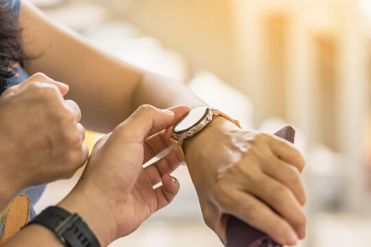 Closeup image of man use thumb finger teaching woman how to use application on smartwatch. Man teach woman how to use a smartwatch before exercise in the gym. Lifestyle technology concept for people.