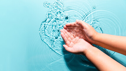 Woman washing cleaning hands by both two hands purity transparent water blue background copy space....