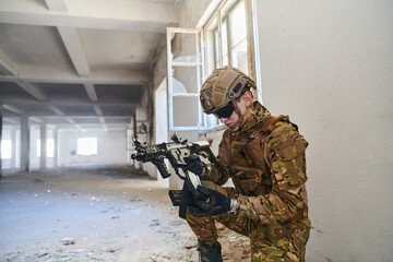 Soldier in action near window changing magazine and take cover
