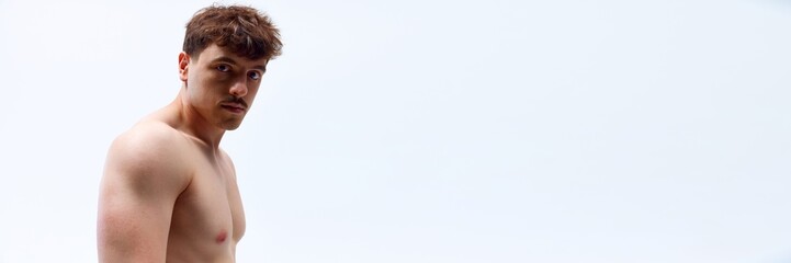 Portrait of handsome young man with muscular body posing shirtless in underwear on white studio background. Concept of man's beauty, sport and health, athletic body. Banner. Copy space for ad