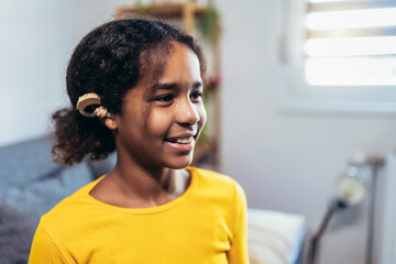 Beautiful smiling black deaf girl wearing a hearing aid