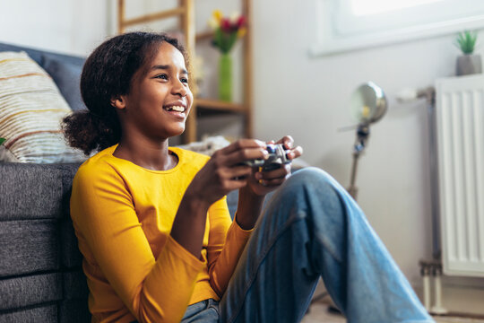 Young African American little girl at home playing video games