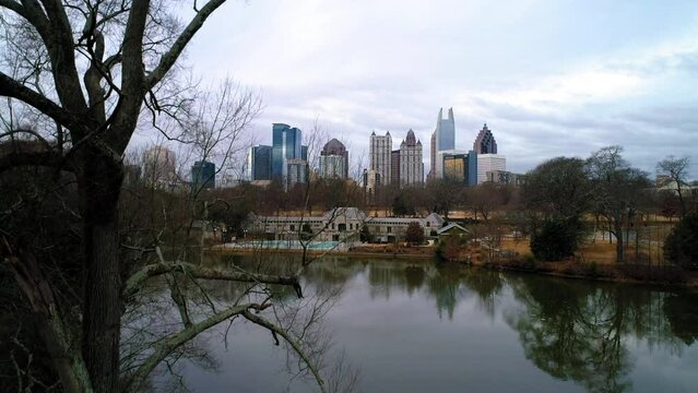 Aerial Shot Of Lake Clara Meer Near Swimming Pool And Buildings, Drone Ascending Near Bare Trees In City Against Sky - Atlanta, Georgia