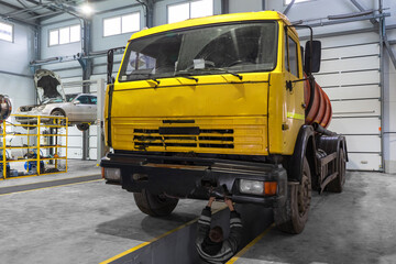 An old truck with damage in a car service under repair.