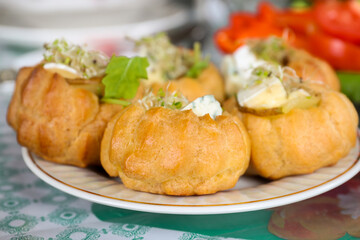 Profiteroles with cheese and pear on the festive table in the afternoon